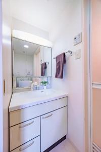 a bathroom with a white sink and a mirror at Flowing home in Nagoya