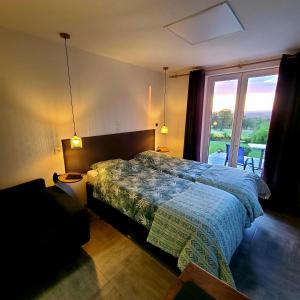 a bedroom with a bed and a large window at Studio L'audrerie. in Saint-Pardoux-Corbier