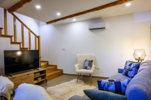 a living room with a couch and a flat screen tv at Tréguas D'Inverno I in Seia