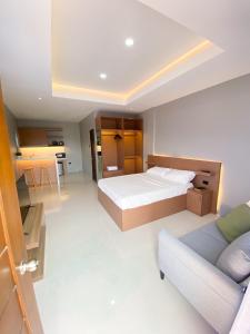 a large bedroom with a bed and a couch at Barsons Transient Unit in Pagbilao