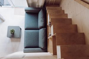 a staircase in a house with a blue couch at Tiny House 2 Dünenblick in Freest +10 photos