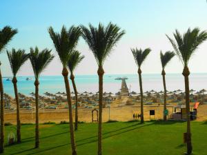 a group of palm trees in front of the ocean at Stella Beach Resort & Spa Makadi Bay - 24 HRS All Inclusive in Hurghada