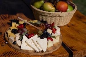 ein Teller mit Käse und Obst mit einem Korb Äpfel in der Unterkunft OKON Highlands Cottages & Camp in Yenokavan