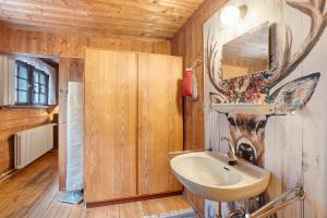 a bathroom with a sink and a deer head on the wall at Zähringer Hütte in Menzenschwand-Hinterdorf +29 photos