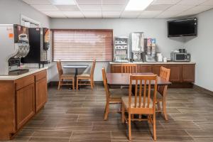 cocina y comedor con mesa y sillas en Super 8 by Wyndham O'Fallon en O'Fallon