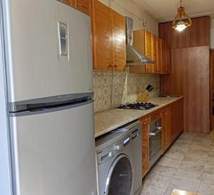 a kitchen with a refrigerator and a washing machine at Cozy Haven Hostel in Yerevan