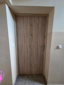 a wooden door in a room with a sink at Apartament COMFORT Centrum 2 in Krotoszyn