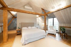 a bedroom with a white bed and wooden ceilings at Rumene Garden House in Rūmene