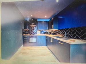 a blue kitchen with blue cabinets and counters at The Tearoom Tarbet in Tarbet
