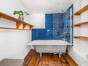 a bathroom with blue tiles and a tub at Pass the Keys Cotswold Country Style Living Chipping Norton in Chipping Norton +24 photos