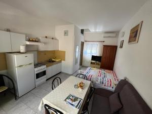 a kitchen with a couch and a table in a room at Apartman Bisa in Jadranovo +6 photos