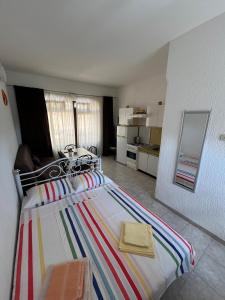 a bedroom with a bed with a striped blanket on it at Apartman Bisa in Jadranovo