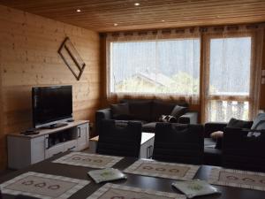 ein Wohnzimmer mit Sofas und Fernseher und einem großen Fenster in der Unterkunft Appartement Châtel 4 pièces, 6 pers, balcon, proche centre - FR-1-676-117 in Châtel