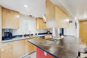 eine Küche mit Holzschränken und einer Arbeitsplatte in der Unterkunft Moose Meadow Cottage in Anchorage