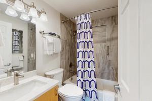 ein Badezimmer mit Toilette und Duschvorhang in der Unterkunft Moose Meadow Cottage in Anchorage + 19 Fotos