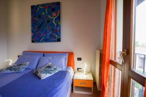 a bedroom with a blue bed and a painting on the wall at Fiordaliso in Montichiari