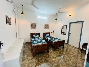 two twin beds in a room with white walls at THEE Confort rooms in Pondicherry