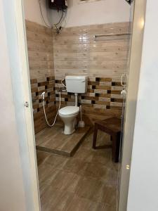 a bathroom with a toilet and a wooden wall at THEE Confort rooms in Pondicherry +11 photos