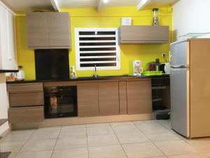 una cocina con armarios marrones y una pared amarilla en Le gîte les haut de la Marina, en Basse-Terre