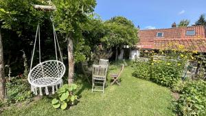 due sedie e un'altalena in giardino di Maison de Campagne Authentique – Havre de Paix pour Âmes Sensibles a Bernay-en-Ponthieu