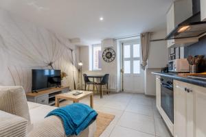 a kitchen and living room with a couch and a table at Studio Les Etoiles de Chasselay in Chasselay