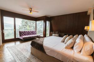 a bedroom with a large bed and a balcony at Masia Boutique con Infinity Pool in Calvinyá