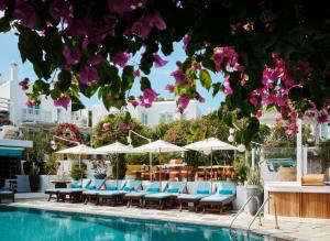 a swimming pool with lounge chairs and umbrellas at Belvedere Mykonos - Main Hotel - The Leading Hotels of the World in Mikonos +75 photos