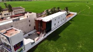 an overhead view of a building with green grass at Sixth Star Inn in Uttamapālaiyam