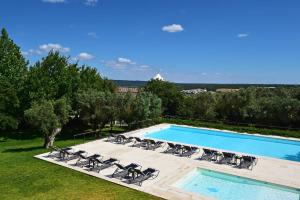 a pool with chaise lounge chairs and a swimming pool at Pousada Castelo de Alcacer do Sal in Alcácer do Sal