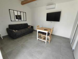a living room with a couch and a table at Studio Saint Maximin la Sainte baume in Saint-Maximin-la-Sainte-Baume