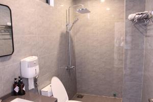 a bathroom with a shower with a toilet and a sink at Gạo Homestay-Hue in Hue +20 photos