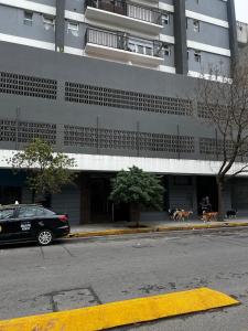 een auto geparkeerd voor een groot gebouw bij Alfonsina Departamento cerca del mar in Mar del Plata