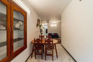 a dining room with a table and chairs at Varsha Homestay with Kitchen, Opposite Botanical Garden, 500 meters from New Bus Stand, Railway Station, and Rock Beach, Pondicherry in Puducherry