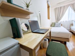 a laptop on a desk in a room with a bed at Laze Nakano 2bed Travel Work Broadway in Tokyo