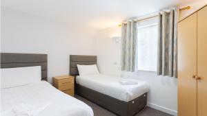 a bedroom with two beds and a window at North Devon Getaways in Ilfracombe
