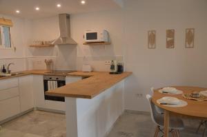 eine Küche mit einer Holzarbeitsplatte und einem Tisch in der Unterkunft Benalmádena Beach Apartment in Benalmádena
