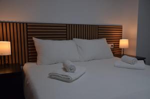 ein großes weißes Bett mit zwei Handtüchern darüber in der Unterkunft Benalmádena Beach Apartment in Benalmádena + 32 Fotos