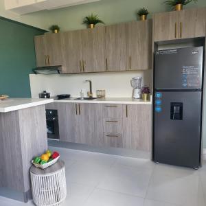 a kitchen with a refrigerator and a bowl of fruit at Gold Reef 1, Villas Bavaro, Punta Cana in Punta Cana
