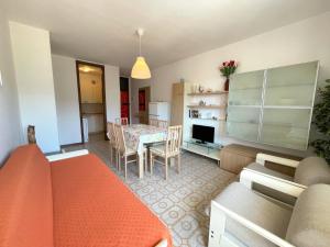 a living room with a couch and a dining room at Cozy flat with shared pool in Porto Santa Margherita di Caorle