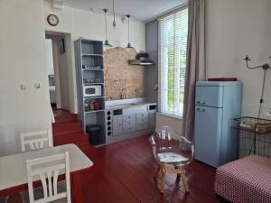 a living room with a table and a refrigerator at Bed & badkamer Het Lemstra Hûs in Harlingen