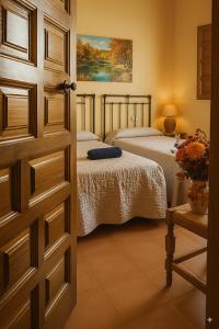 a bedroom with two beds and a door at Casa Rural Las Tejas - Ideal para Familias y Grupos in Bayubas de Abajo +9 photos