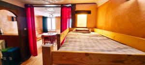 a large bed in a room with red curtains at Loft sur Briançon et Serre Chevalier in Briançon