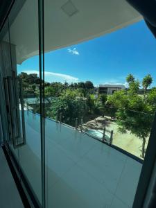a glass window of a building with a view of a park at Comfort Family Santarém access Alter do chão in Santarém