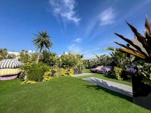 un jardín con césped verde, flores y plantas en Maya Suites - Premium Luxury Stay, en Casablanca