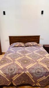 a bed with a quilt on it in a bedroom at Gin Oya Villa in Aluttota