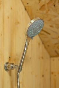 an einer Holzwand befindet sich ein Duschkopf. in der Unterkunft OKON Highlands Cottages & Camp in Yenokavan