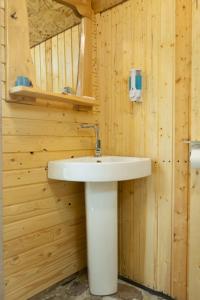 ein Badezimmer mit einem weißen Waschbecken in einer Holzwand in der Unterkunft OKON Highlands Cottages & Camp in Yenokavan + 36 Fotos