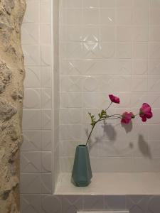 a green vase with pink flowers sitting on a shelf at Ancienne eglise in Vallérargues +31 photos