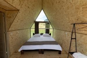 Bett in einem kleinen Zimmer mit Fenster in der Unterkunft OKON Highlands Cottages & Camp in Yenokavan