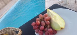 a plate of grapes and a slice of fruit next to a pool at Victoriano in La Rioja